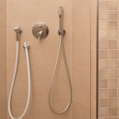 Die Duschkabine ist mit glatten, hellen Fliesen ausgekleidet und bietet eine stilvolle, entspannende Atmosphäre.