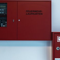 Der Feuerwehrschrank enthält wichtige Informationen und einen Zugang für Löschwasser, gut sichtbar an der Wand angebracht.
