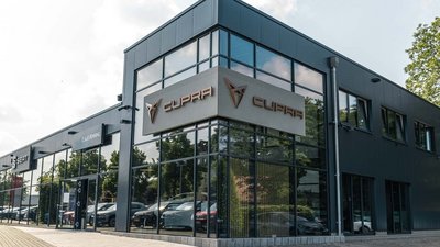 Die elegante Außenansicht eines CUPRA-Autohauses, das durch seine moderne Architektur und das glänzende Logo besticht.