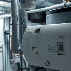 Der Heizungsraum zeigt eine Vielzahl von Heizgeräten, Rohren und einem digitalen Steuergerät, das die Temperatur regelt.